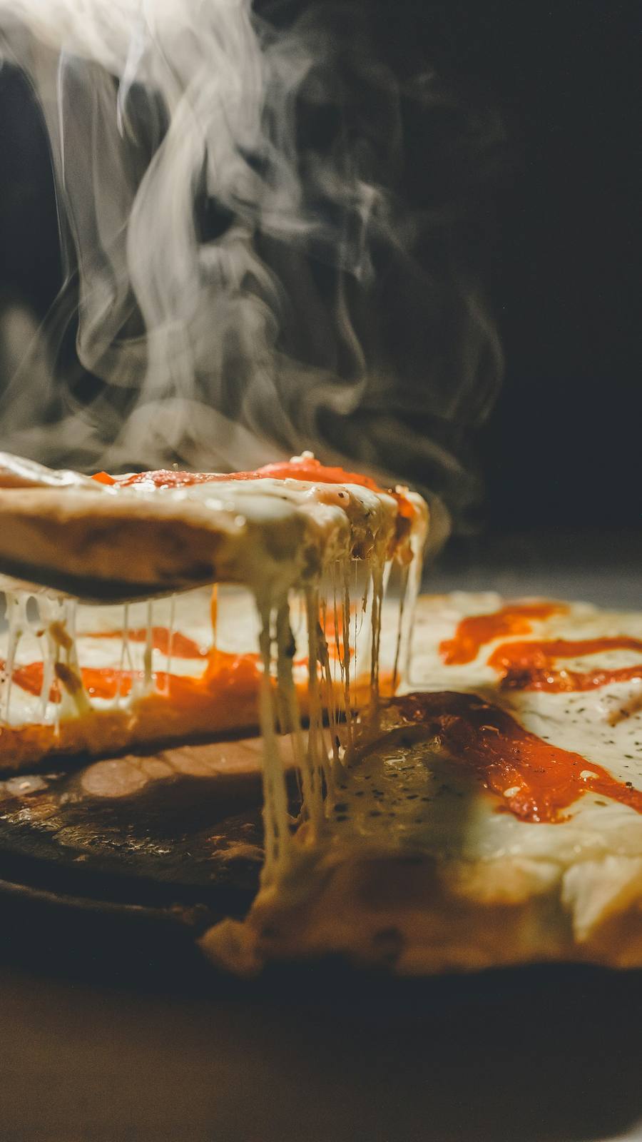 Porción de pizza con queso derretido y vapor